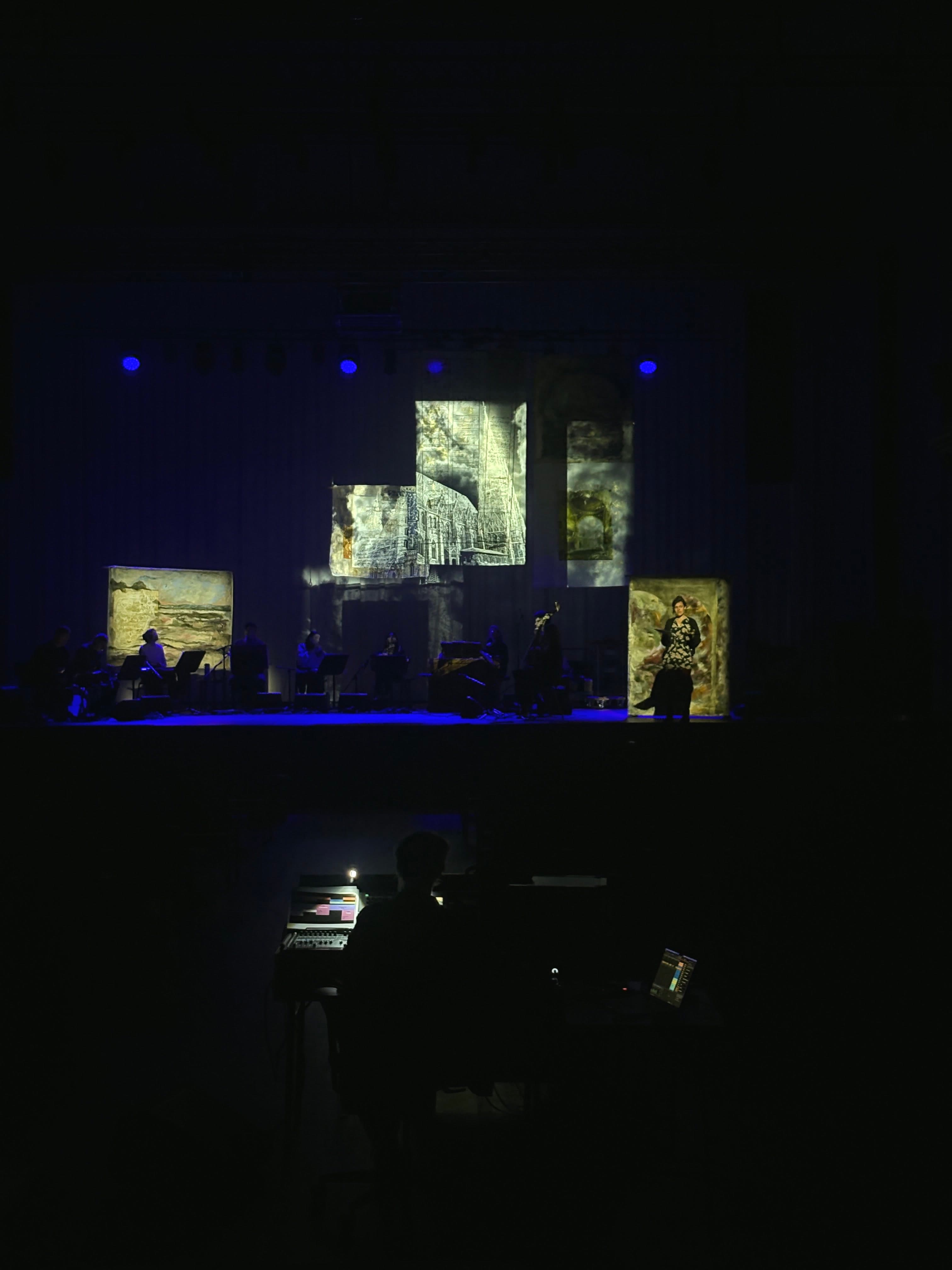 Echoing Travelogues stage view with projection fragments and performer image